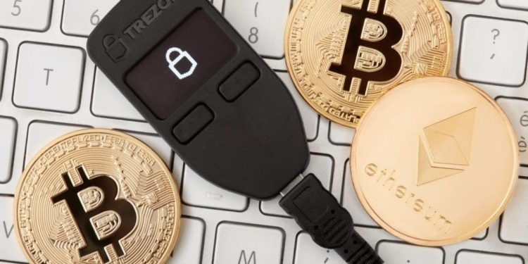 MILAN, ITALY- FEBRUARY 2: Black Trezor hardware wallet for cryptocurrency with golden bitcoin with black reflection and ethereum coins on keyboard on February 2, 2018 in Milan
